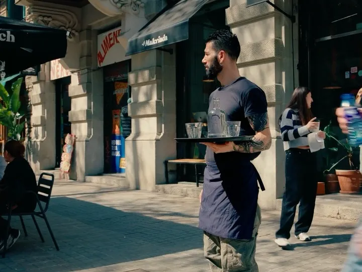 Un cambrer porta plats a la terrassa de la Ronda de Sant Pere